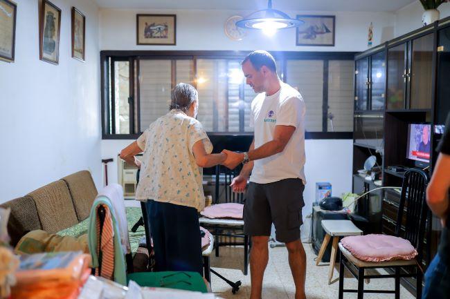 Emilia, survivante de la Shoah, avec un bénévole de Latet le 11 octobre 2023 © Latet