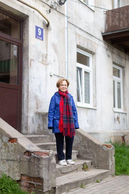 Mala Tribich devant l'immeuble de son enfance à Piotrkow Trybunalski en 2022 © Photographie de Sam Churchill